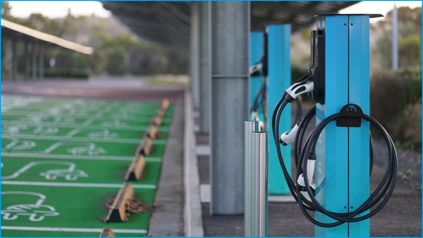 A medium shot of an electric vehicle charging station, with many empty charging bays and chargers next to them.