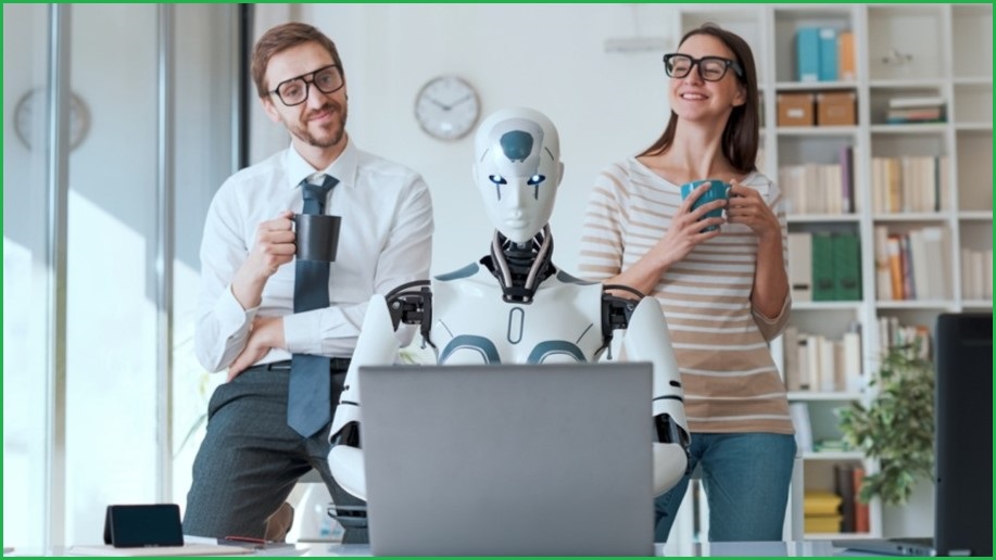 Two humans working with a robot, looking at a laptop screen.