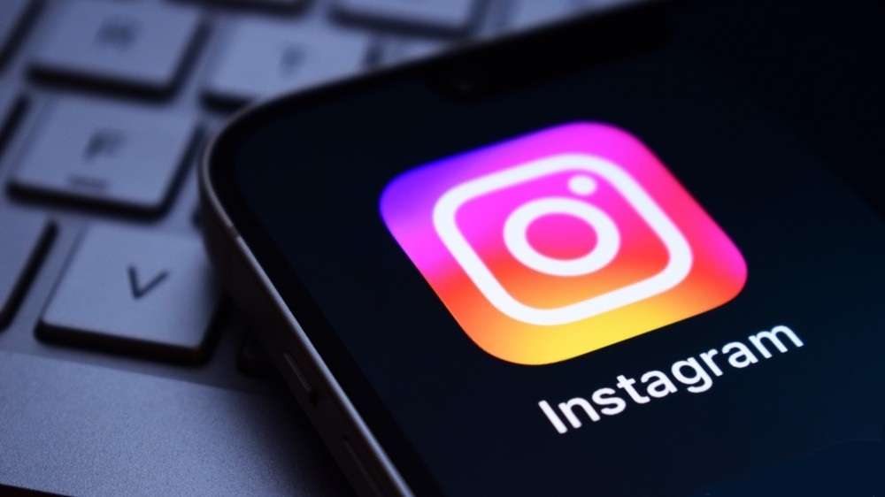 Instagram logo on a screen with a keyboard in the background.