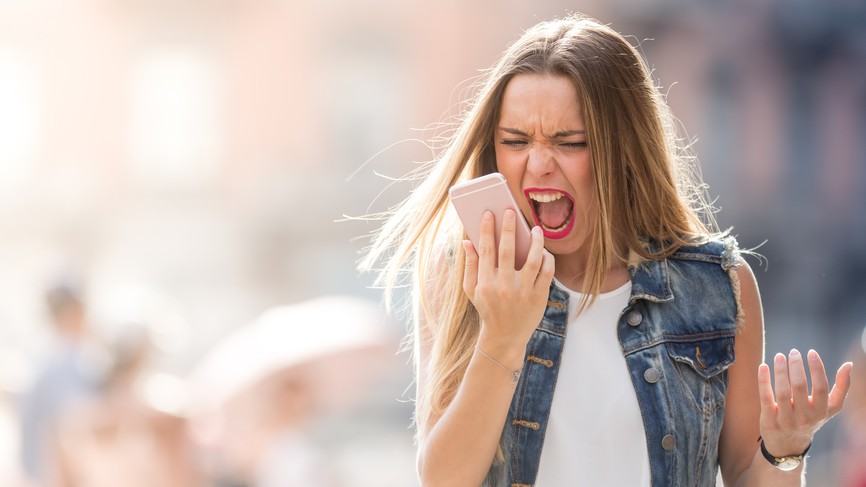 Woman screaming into a mobile phone.