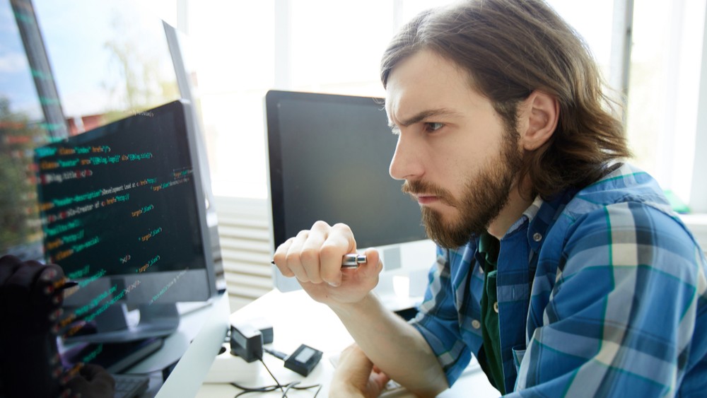 Man looking intensely at a computer monitor.