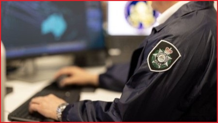 Police officer's hands on a keyboard, looking at a screen.
