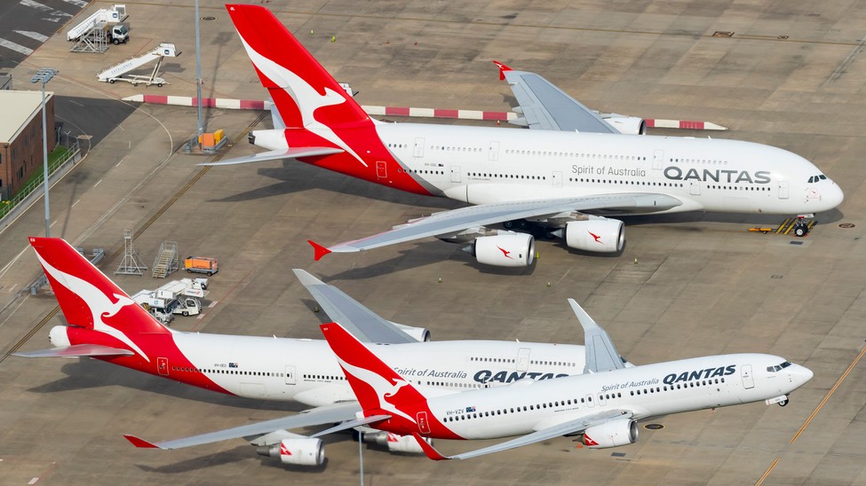 Three Qantas planes parked at the airport.