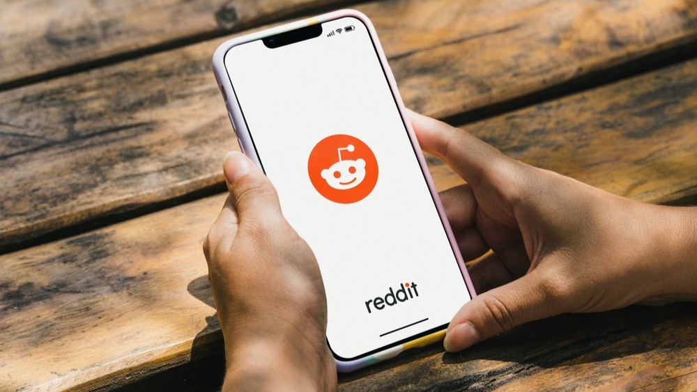 A person using Reddit on a mobile phone.