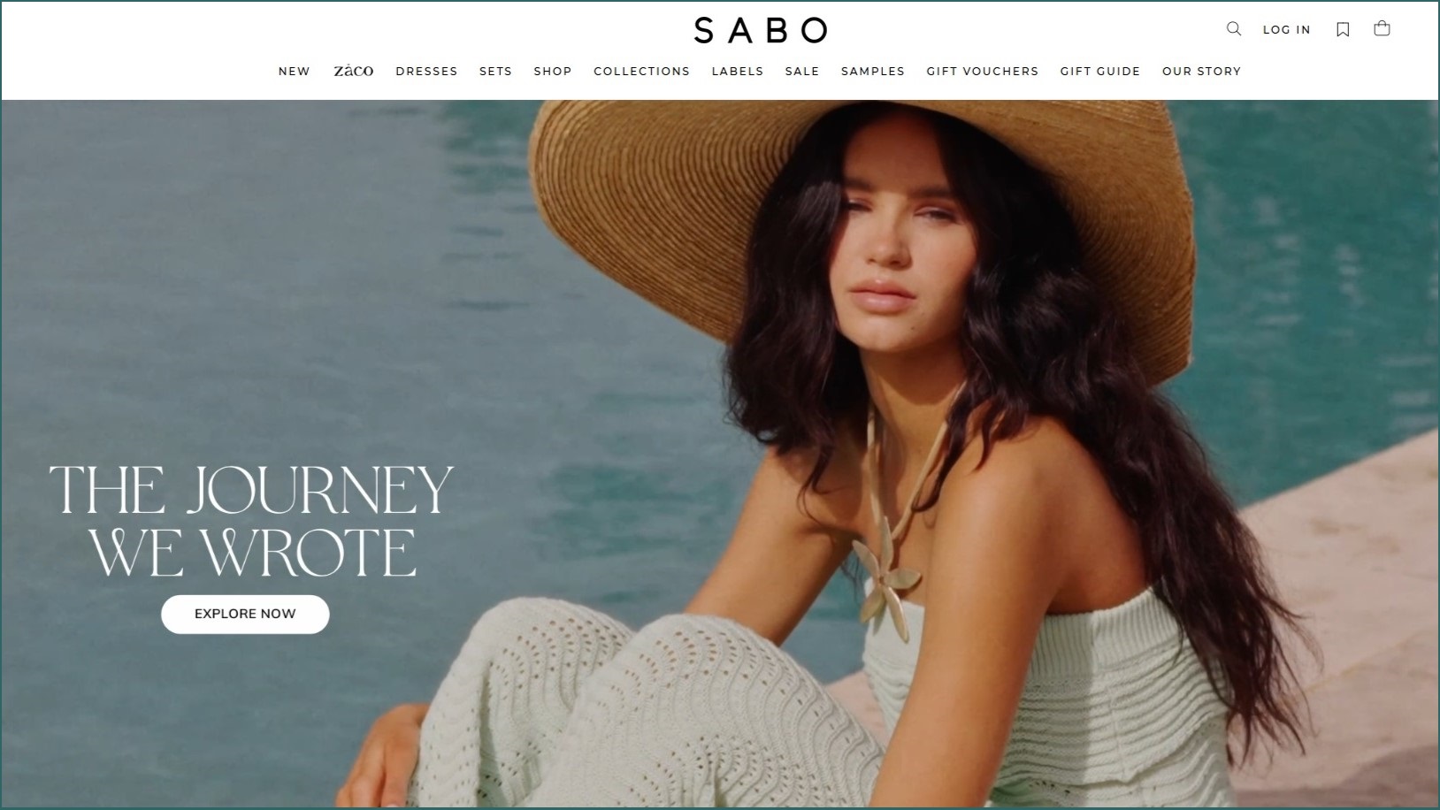 Woman wearing a large hat with water in the background.