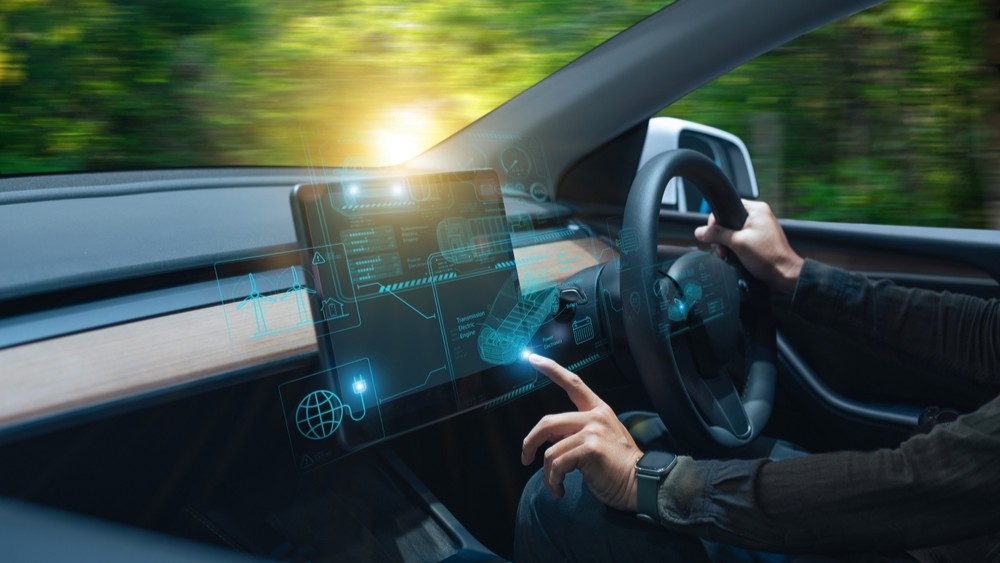 Person driving a smart car, touching the smart screen.