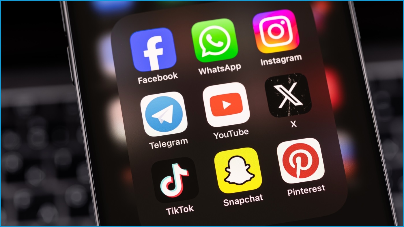 A close up of an iPhone screen displaying social media apps from the likes of Facebook, Instagram, YouTube, X, TikTok, Snapchat