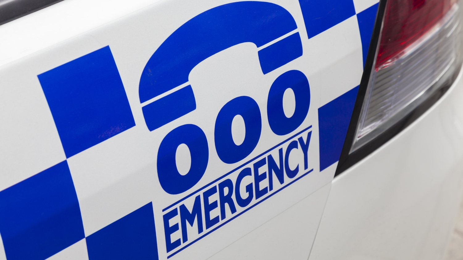 A close up of a Triple Zero Emergency logo on the back of a police car.