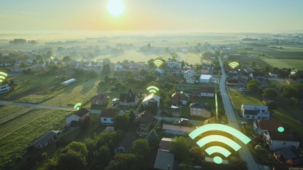 Houses spread far apart with superimposed Wi-Fi symbols.