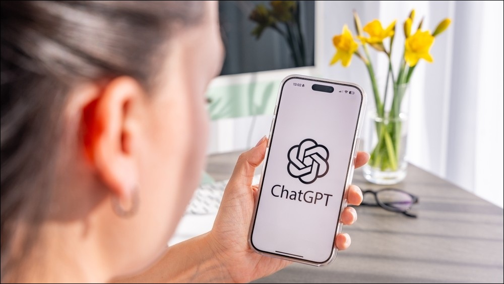 Woman looking at ChatGPT on phone screen.