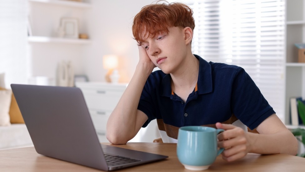 Male students sitting at computer.