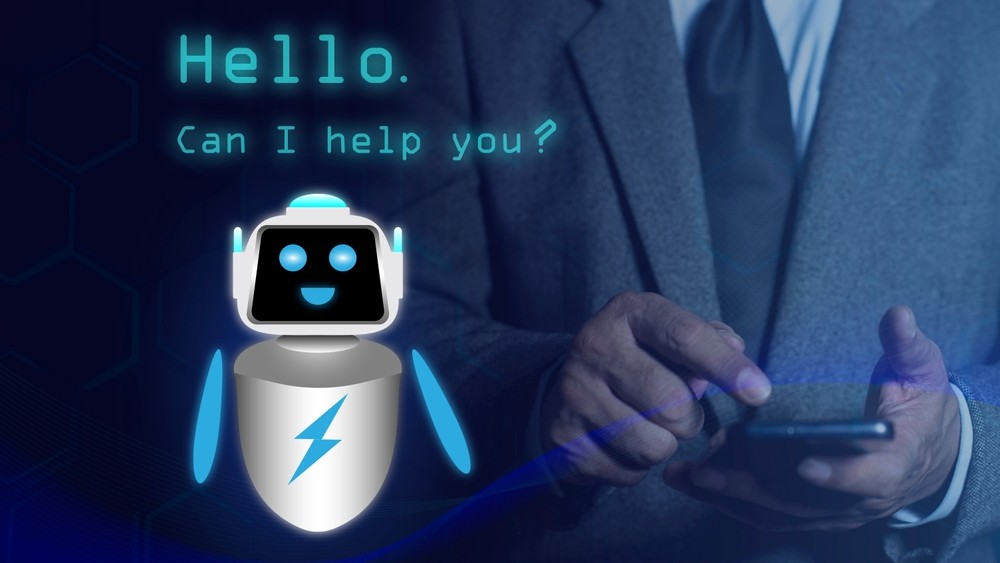 Robot saying 'Hello. Can I help you' next to photo of man in business suit holding mobile phone.