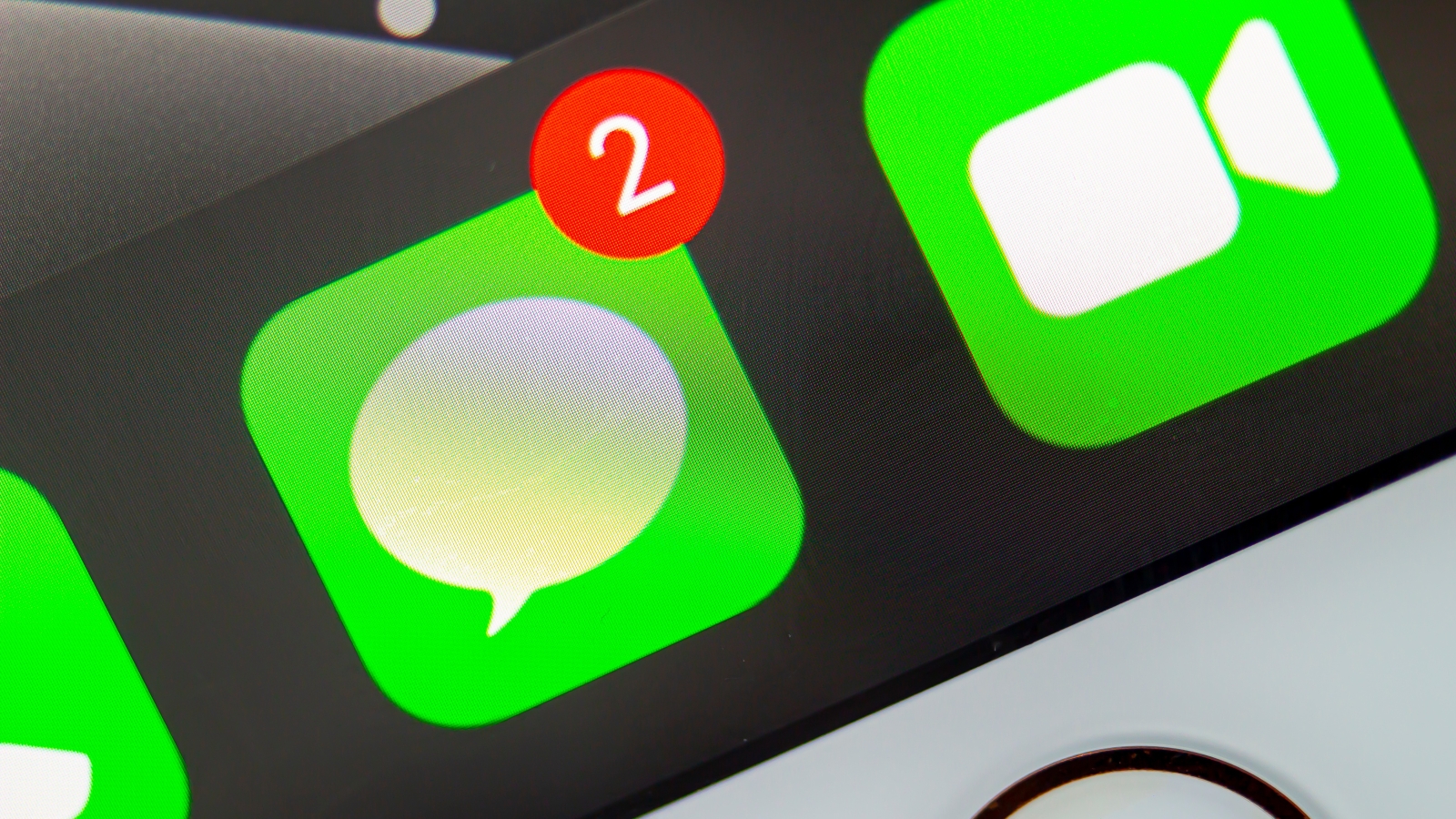 A close up of the iOS Messages app icon on an iPhone screen, showing two new notification badges