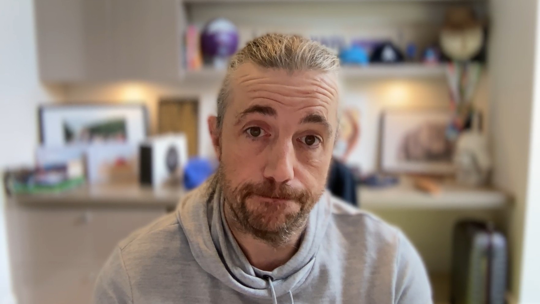 A close up of Mike-Cannon Brookes speaking to his computer camera from inside an office.