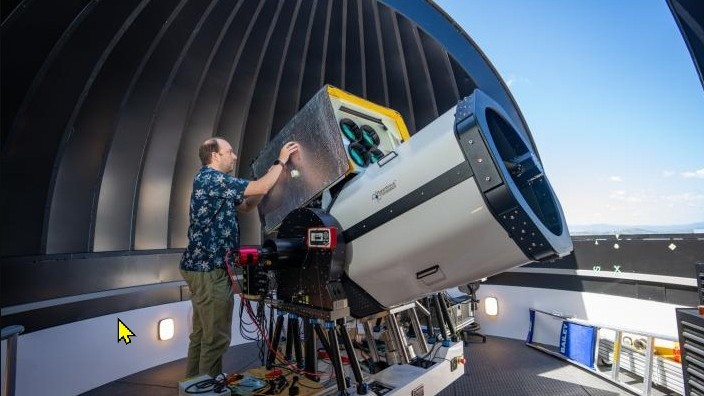 Man setting up large telescope.