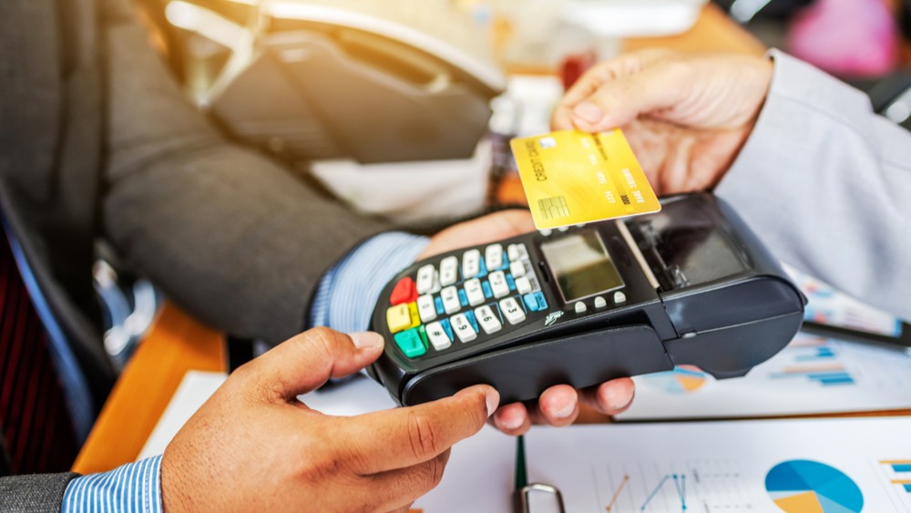 Person paying for goods with a credit card.
