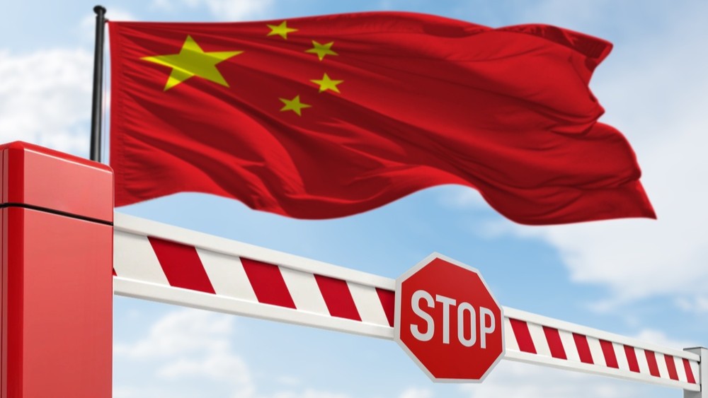 Chinese flag above a stop sign.