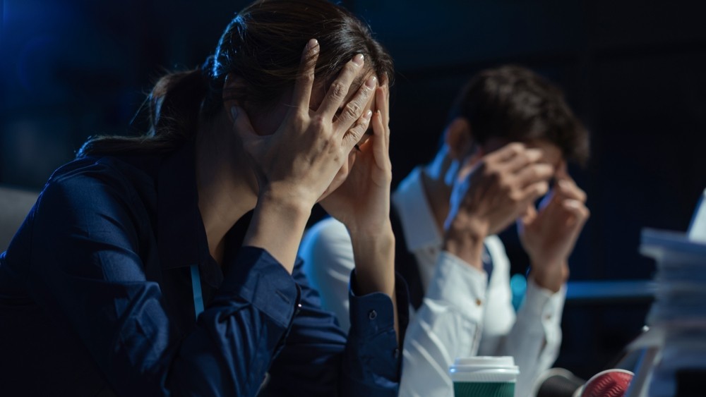 Frustrated executives holding their heads.