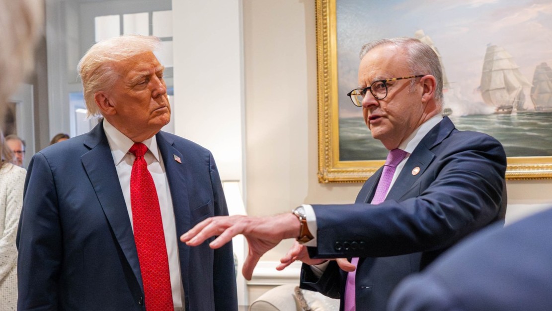 A medium shot of Donald Trump and Anthony Albanese in suits and ties, speaking inside a building.