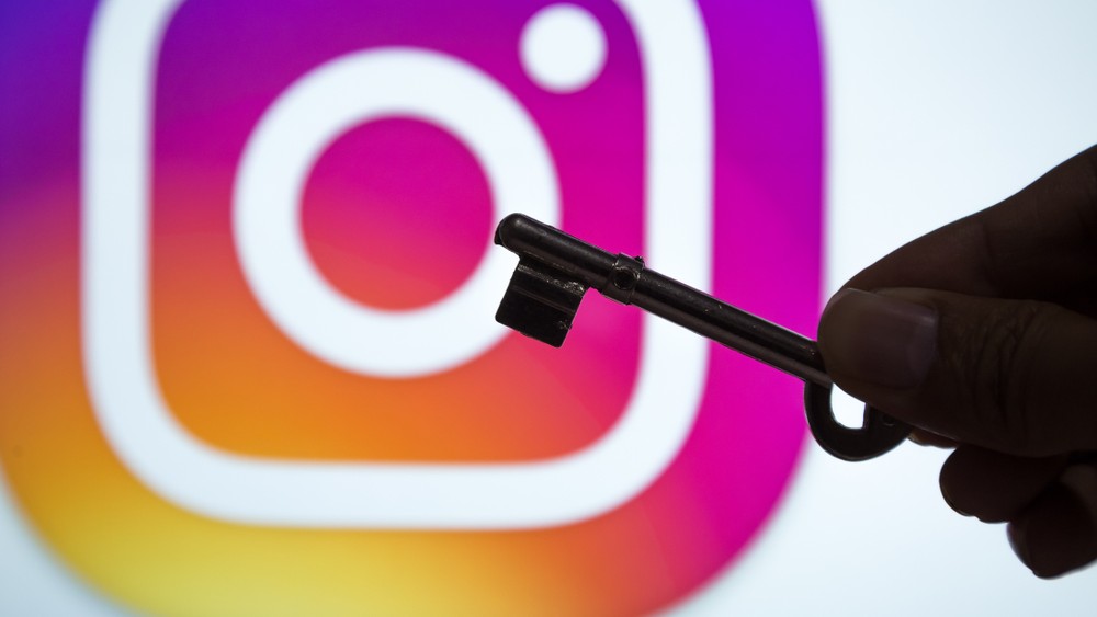 A person holding a key in front of the Instagram logo.