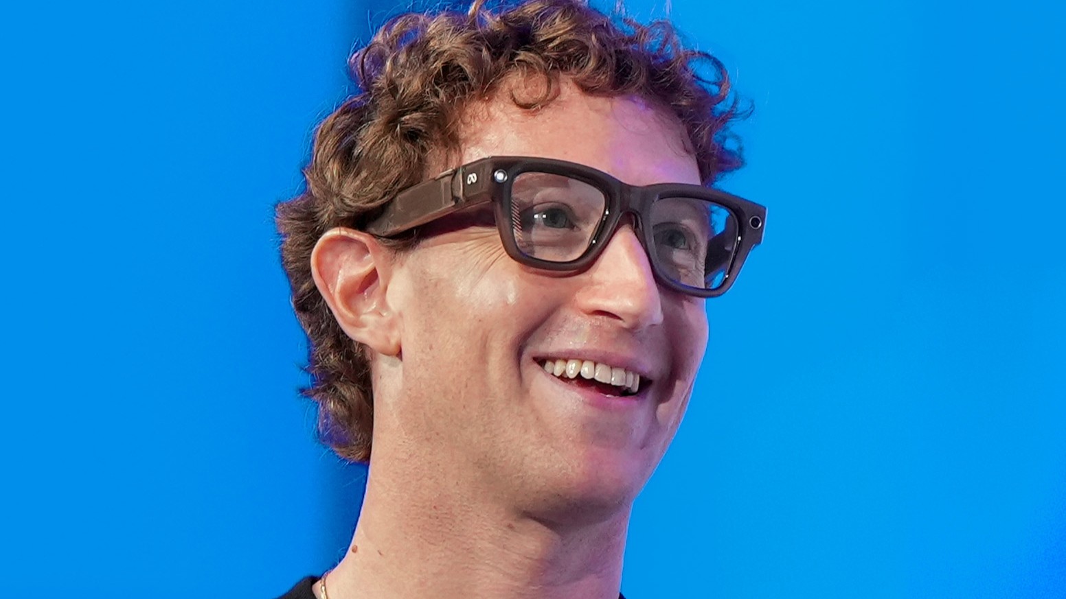 A close up of Mark Zuckerberg wearing Meta smart glasses.