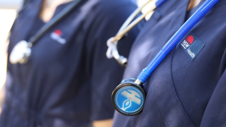 Two nurses dressed in NSW Health uniforms.