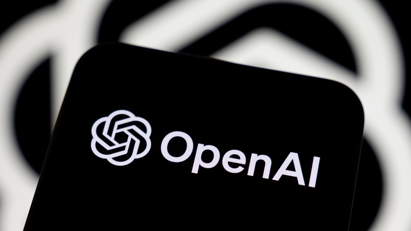 A closeup of a smartphone displaying the OpenAI logo.