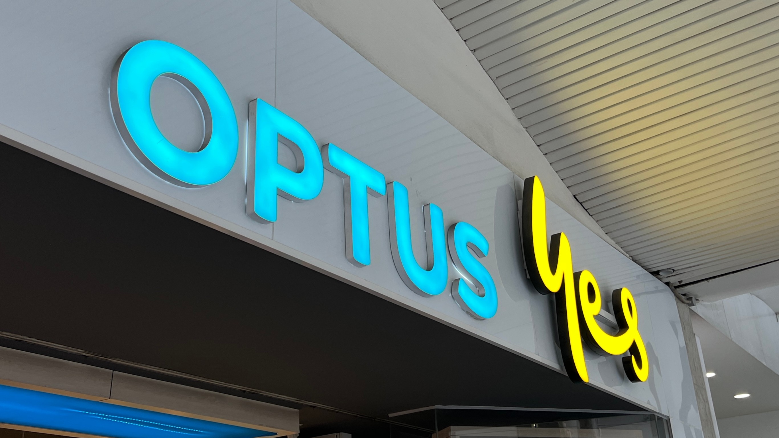 A close up of the Optus 'Yes' logo on top of a store entrance.