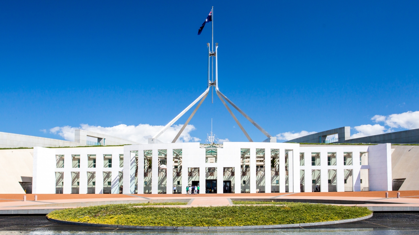 A wide exterior photo of parliament house in Canberra on a sunny day.