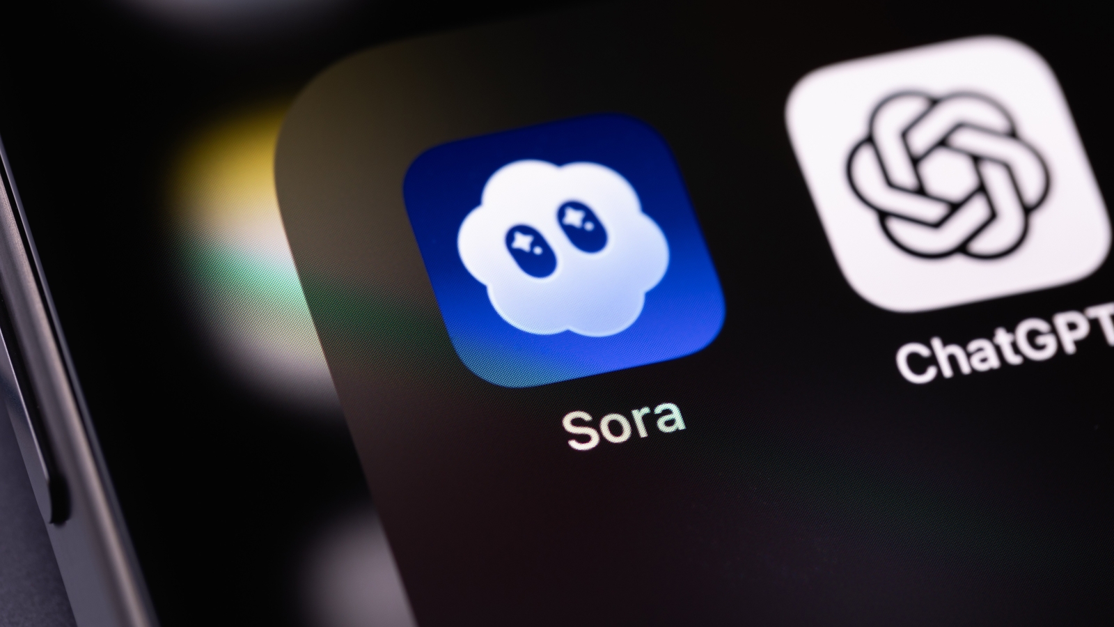 A close up of a smartphone screen displaying the Sora and ChatGPT app icons.