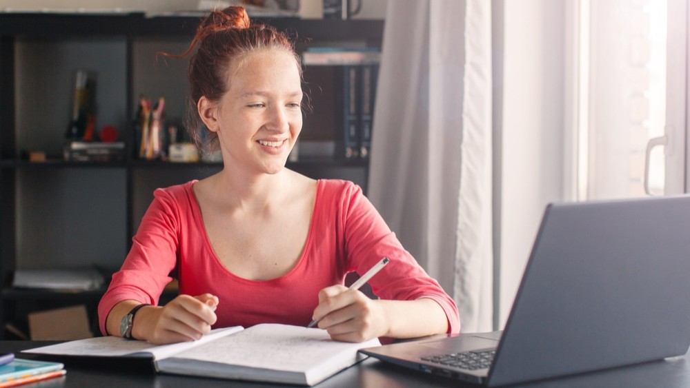 Female students working on an assessment at home.