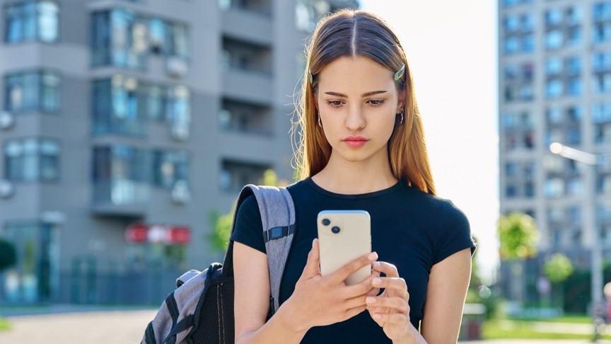 Teenager interacting with mobile phone screen.
