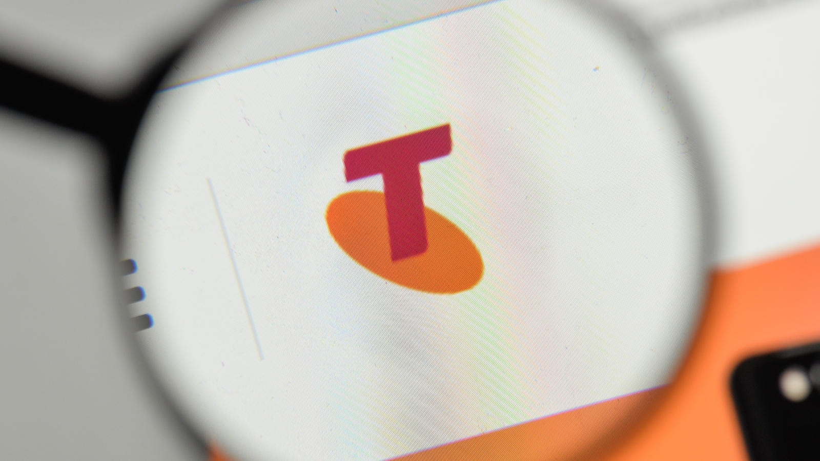 A close up of the Telstra logo on Telstra website, covered by a magnifying glass.
