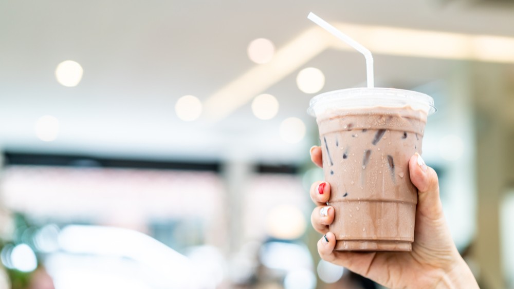 A hand holding an iced coffee.