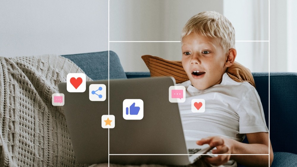 Young boy accessing social media on a laptop.