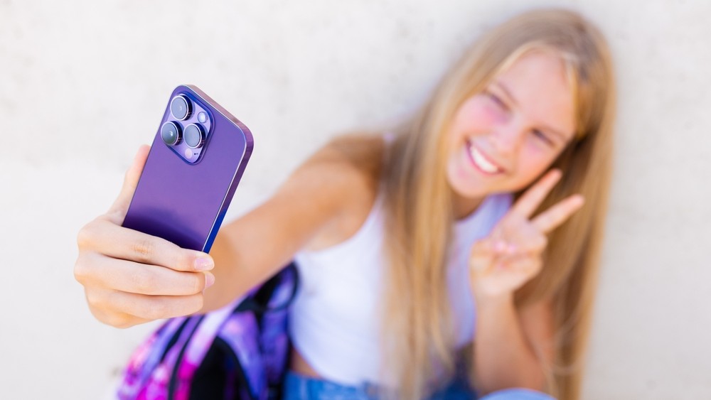 Young female teenager taking selfie.