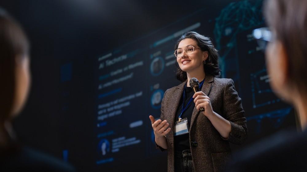Woman speaking in front of an audience.
